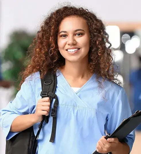 mulher sorrindo de mochila das costas segurando uma prancheta