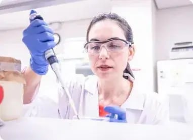 mulher de oculos e luvas fazendo experimento